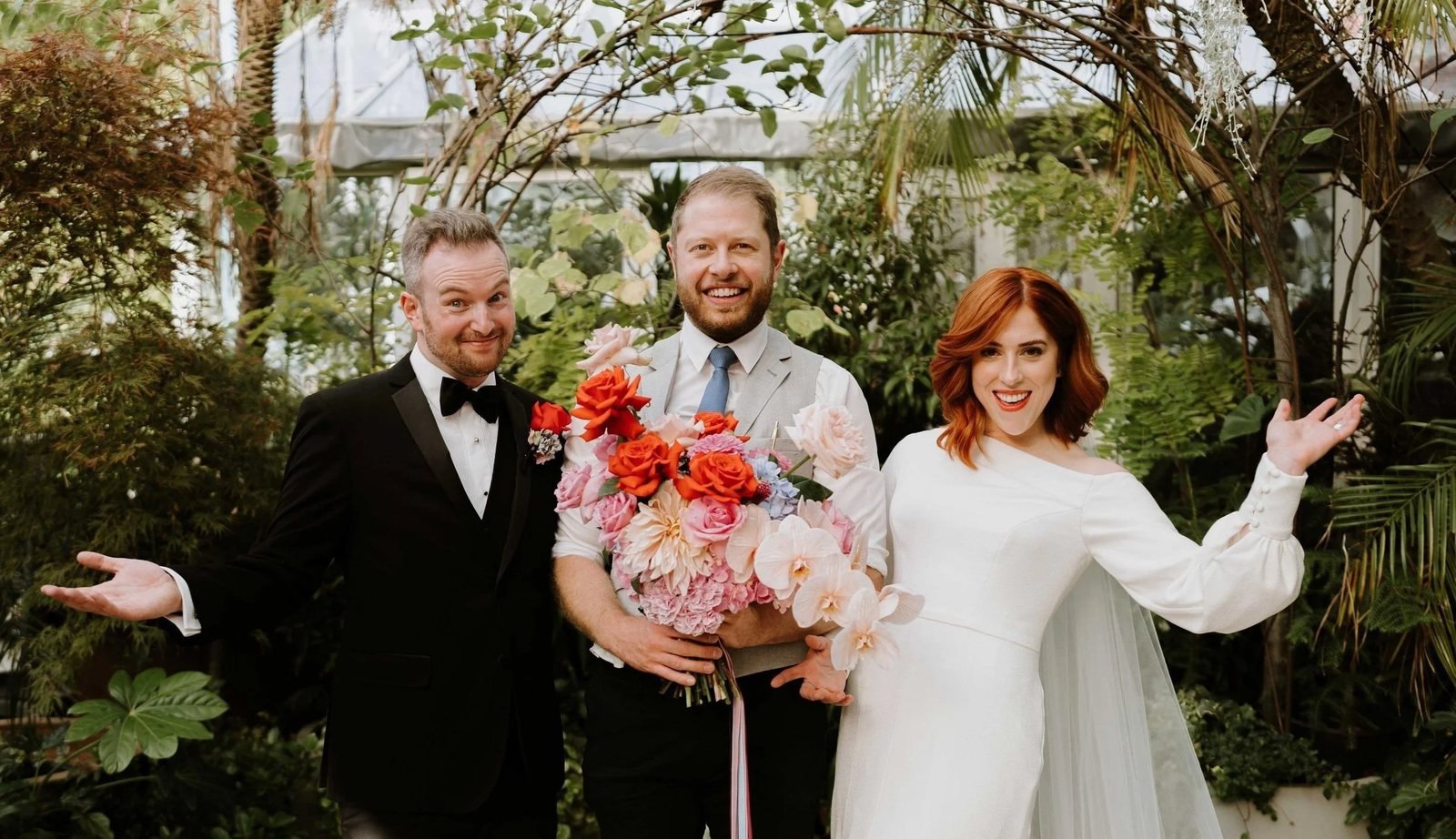 The celebrant posing with newlyweds and their bouquet