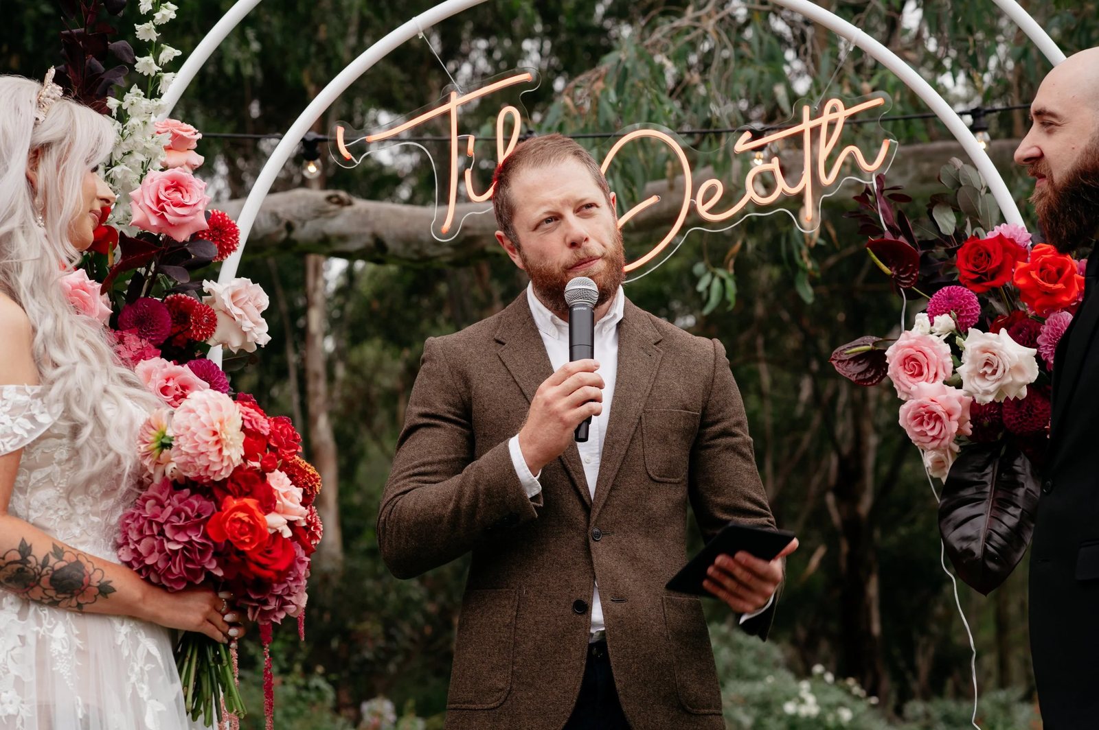 The celebrant officiating a ceremony under a neon sign